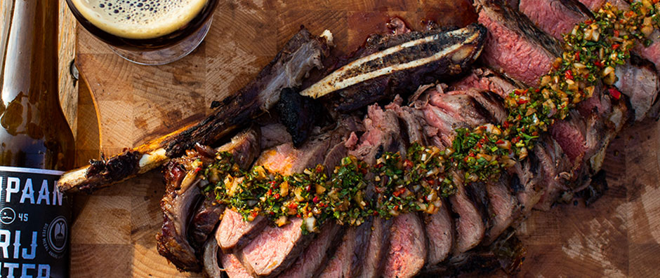 Caveman-style Black Angus tomahawk steak met rozemarijn, salie, knoflook en Argentijnse chimichurrie